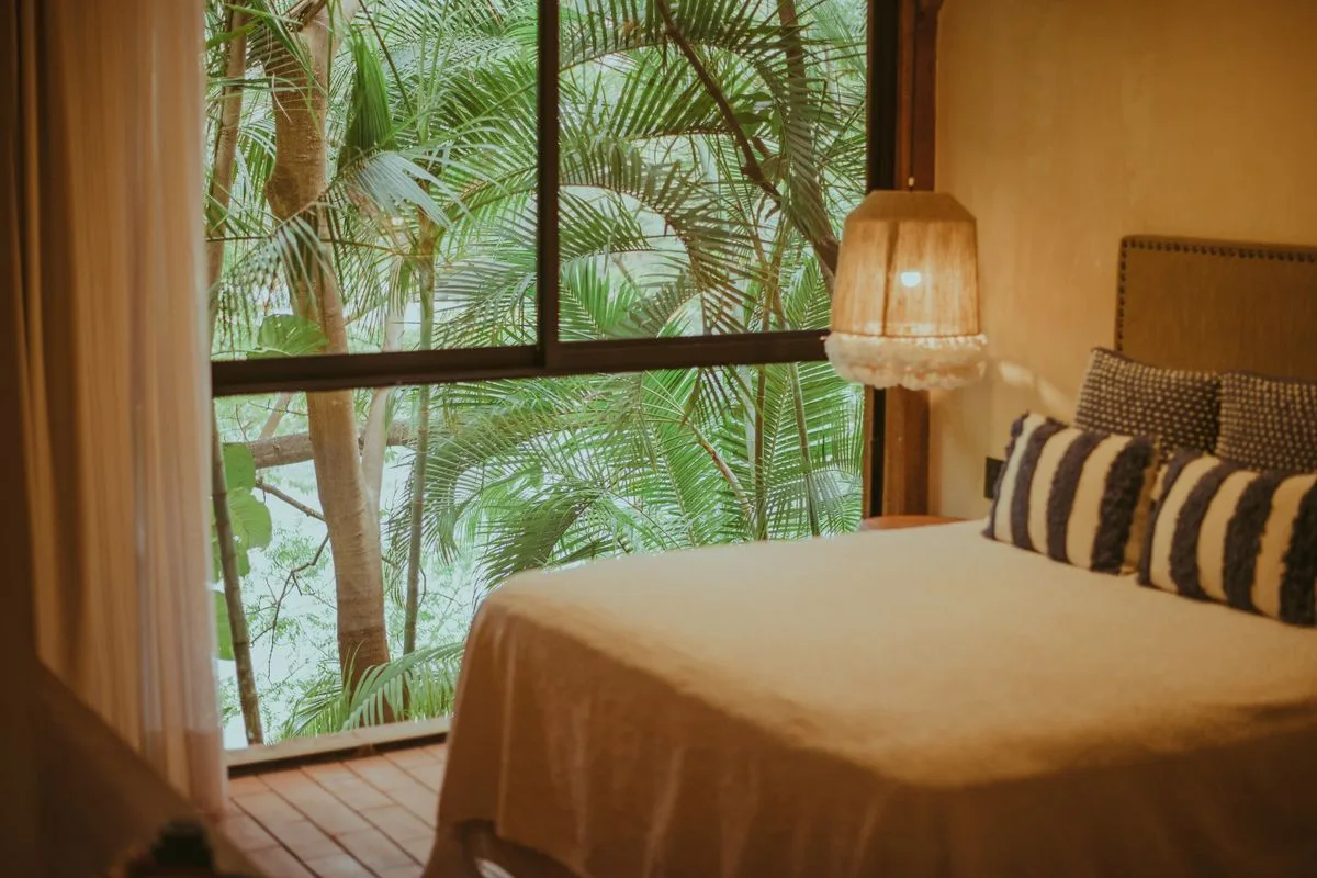 La chambre côté baie vitrée, sur la canopée des jardins